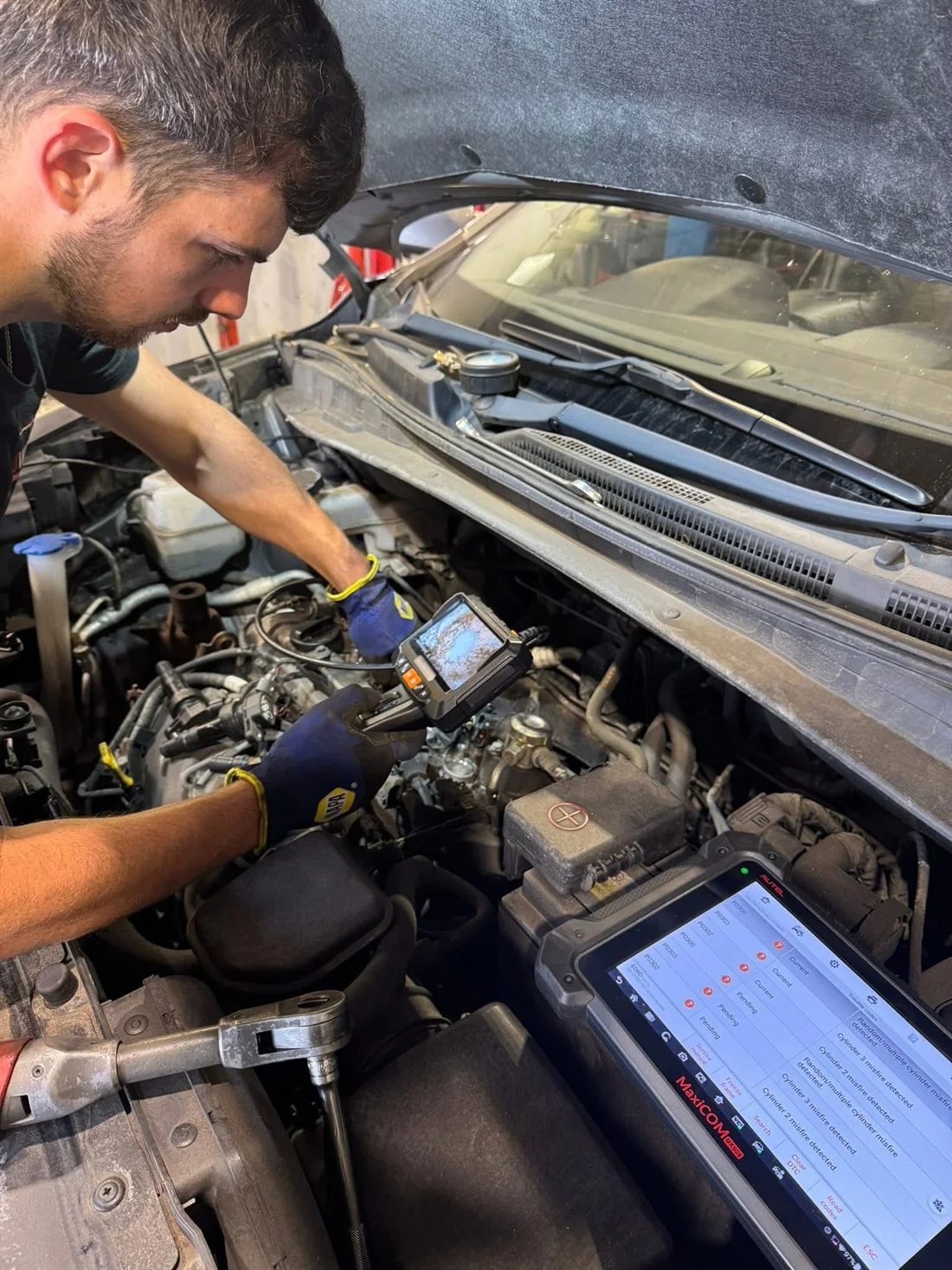 Elliot working under the bonnet with diagnostic equipment at Motoworx