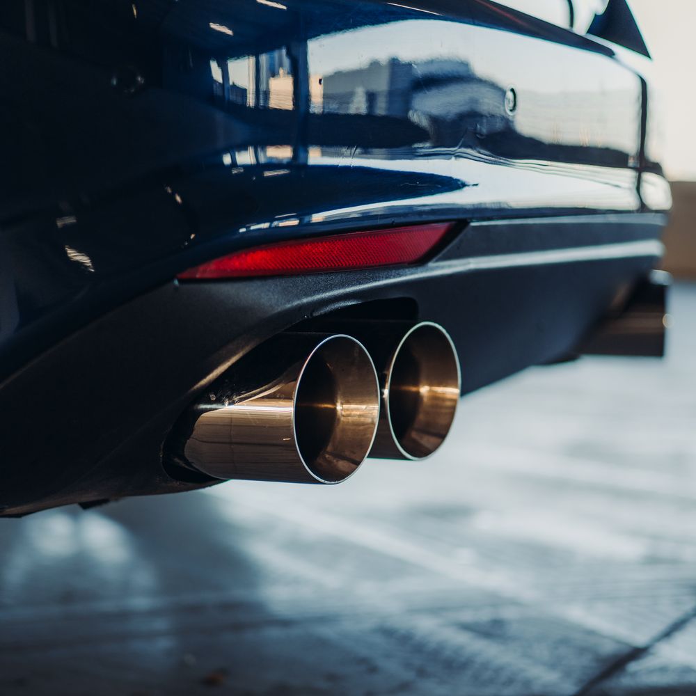 Twin polished exhaust tips on the back of a car
