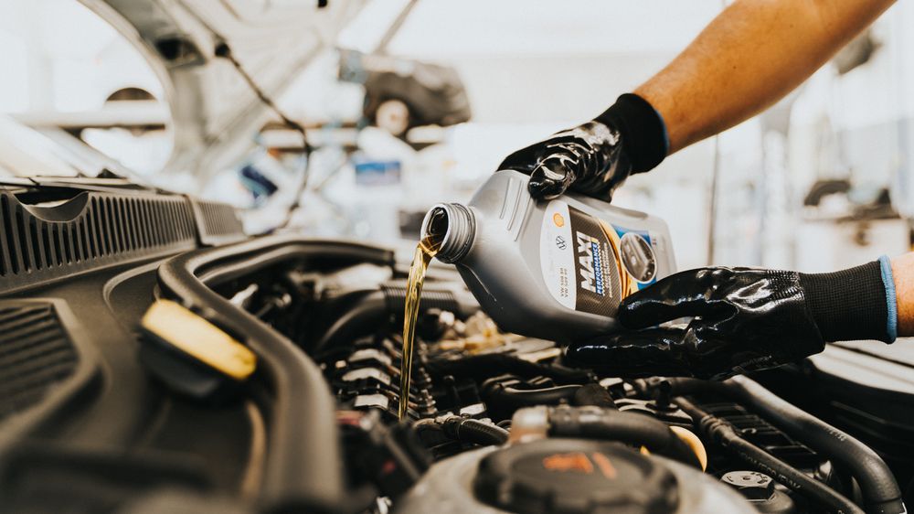Fresh oil being poured into a car engine during a service
