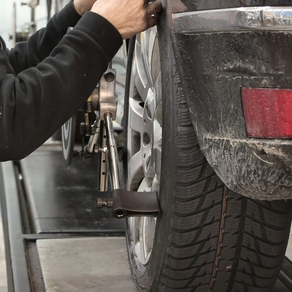 An alignment clamp being fitted to a car's wheel
