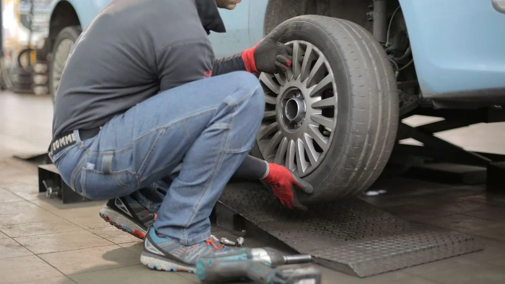 A wheel being changed on a car raised in the workshop